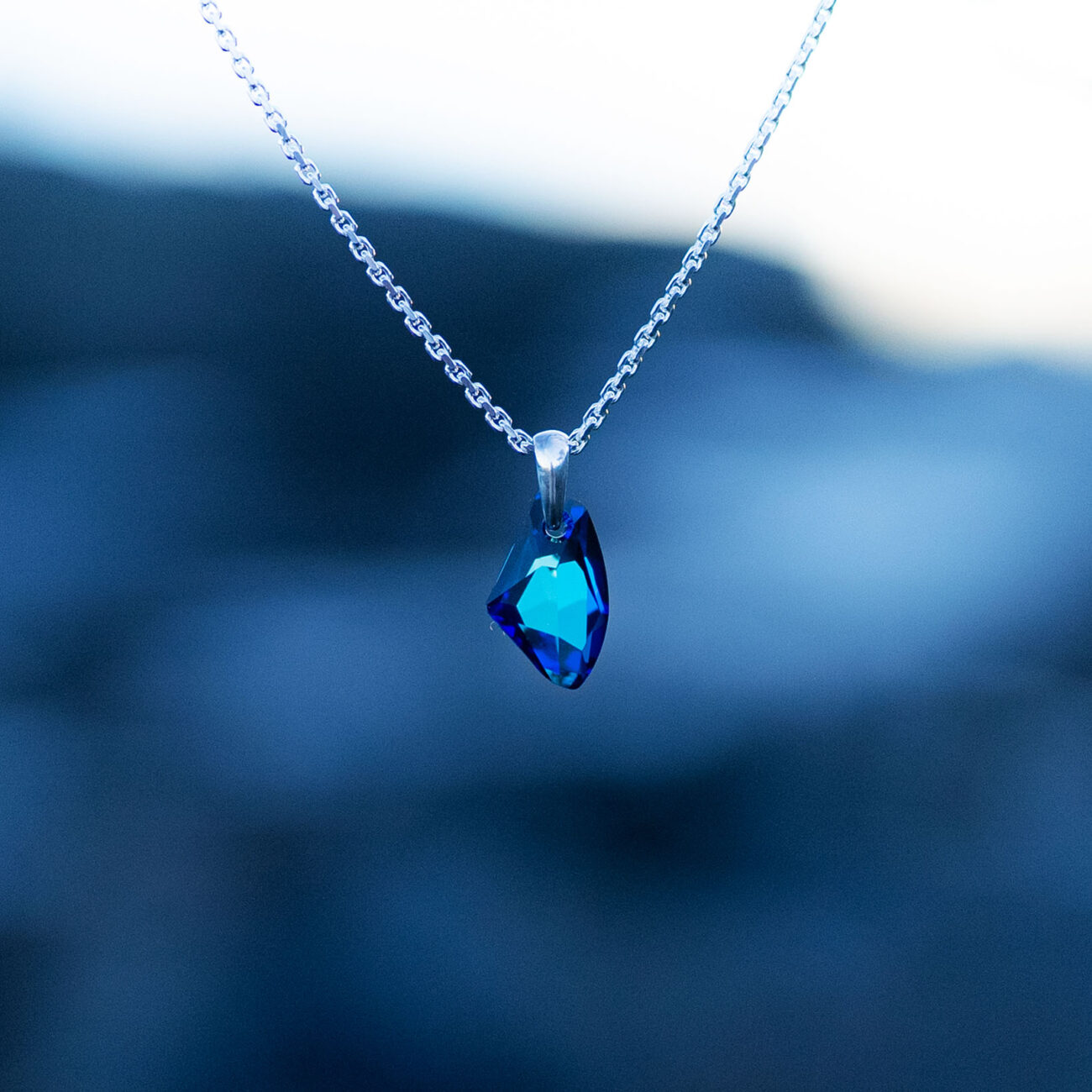 Nebula Necklace with a radiant blue Swarovski crystal pendant on a sterling silver chain, inspired by the beauty of the cosmos and the night sky