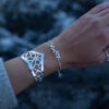 a silver leaf bracelet with delicate leaf details is worn on an arm
