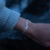 a silver leaf bracelet with delicate leaf details is worn on an arm