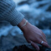 a silver leaf bracelet with delicate leaf details is worn on an arm