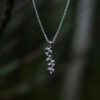 Close up of a silver leaf pendant necklace with delicate botanical details